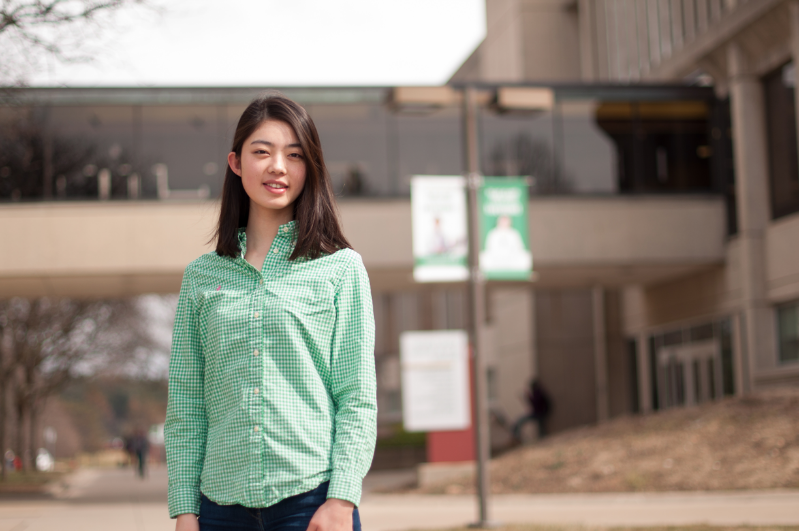 student standing outside on campus